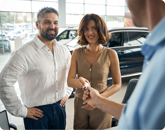 woman taking car key from salesman